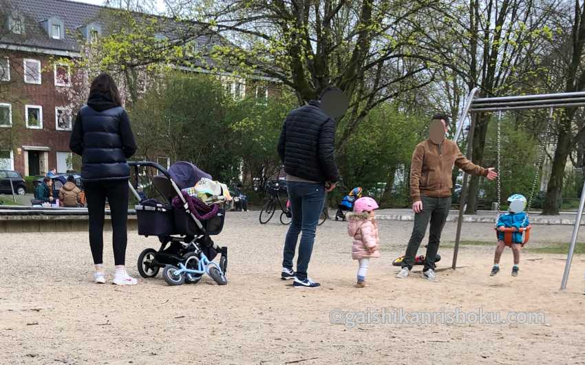 ドイツの公園で子供たちを遊ばせる父親